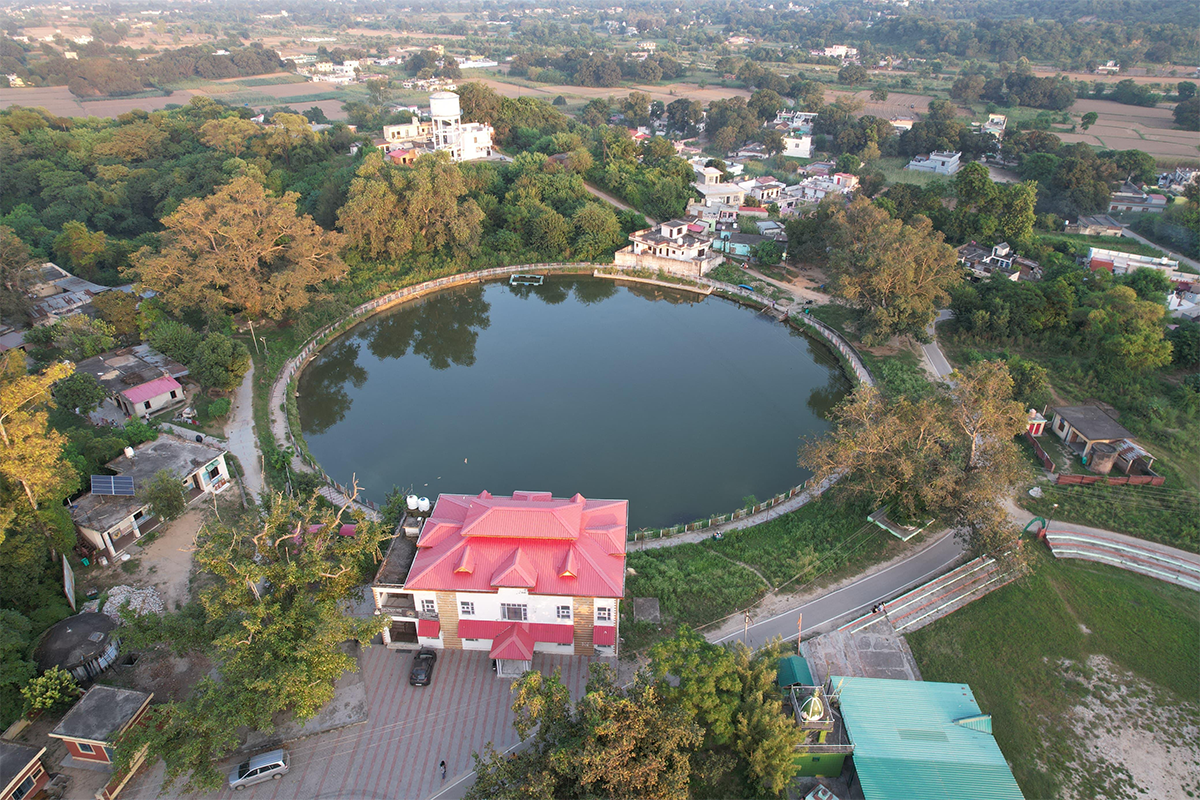 The image depicts a nature-based water conservation effort, with a restored or partially restored pond surrounded by excavated soil and vegetation, reflecting climate resilience and community-led water management. Image courtesy: Office of the Deputy Chief Minister, Himachal Pradesh.